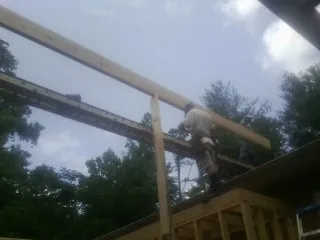 Carpenter setting a ridge beam over a new addition frame — Ice Dam Removal by Roofing Brothers in Bellflower