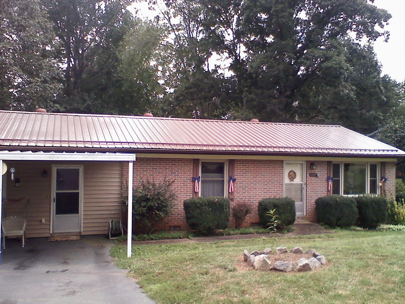 Bronze metal roof and carport on a brick ranch home — Roof Repair work by our crew in Bellflower